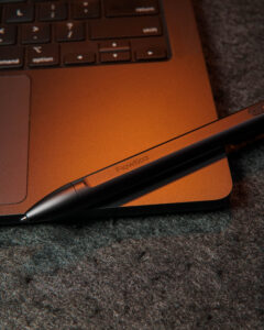 Dark pen macbook branding visible moody
